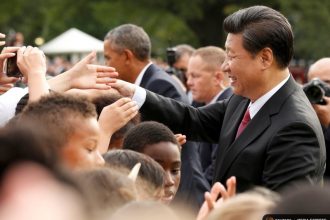 China's President Xi Jinping greets a crowd during his visit with President Obama