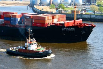 A cargo ship and tugboat in port. Credit: pxhere.com