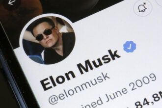 In this photo illustration, the Elon Musk’s Twitter account is displayed on the screen of an iPhone on April 26, 2022. Photo illustration by Chesnot/Getty Images