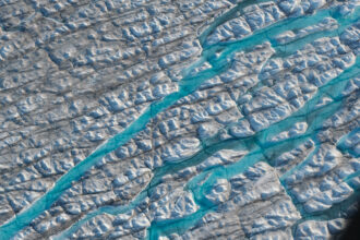In this view from an airplane rivers of meltwater carve into the Greenland ice sheet near Sermeq Avangnardleq glacier on Aug. 4, 2019 near Ilulissat, Greenland. Credit: Sean Gallup/Getty Images
