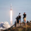 People watch as the SpaceX Falcon Heavy rocket lifts off from launch pad 39A at NASA’s Kennedy Space Center on April 11, 2019 in Titusville, Florida. The rocket is carrying a communications satellite built by Lockheed Martin into orbit. Credit: Joe Raedle/Getty Images