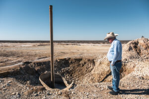Bill Wight looks at the well that leaked enormous volumes of saltwater on his property. It took crews over a month to seal the well and stop the leak. Credit: Sarah M. Vasquez/The Texas Tribune