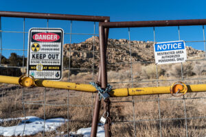 Signs warning of health risks are posted outside the gates of an abandoned uranium mine in the community of Red Water Pond Road, N.M. Credit: The Washington Post via Getty Images