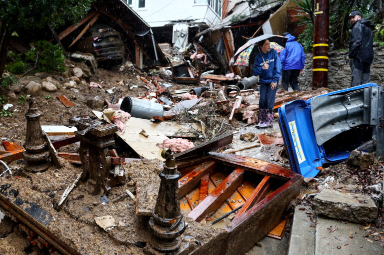 People gather where a home was destroyed by a mudslide as a powerful atmospheric river storm continues to impact Southern California on Feb. 5 in Los Angeles, Calif. Credit: Mario Tama/Getty Images