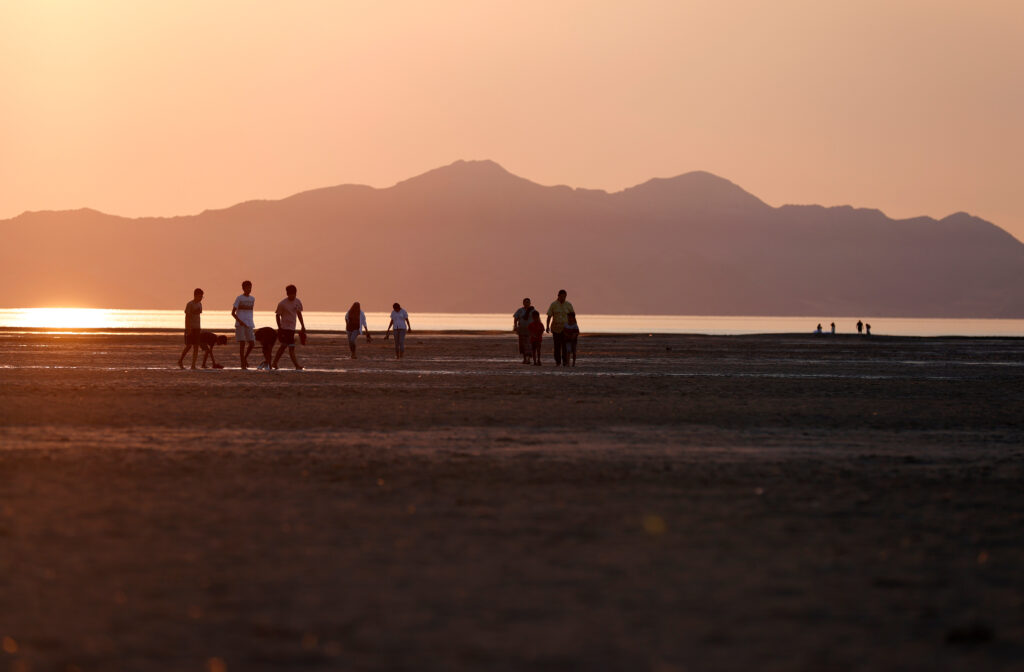 People walk on a section of the Great Salt Lake that used to be underwater on Aug. 2, 2021 near Magna, Utah. Credit: Justin Sullivan/Getty Images