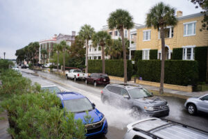 A car drives along a flooded East Bay Street as Charleston, S.C. endured flooding due to the combination of an offshore storm system and an unusually high king tide on Nov. 5, 2021. Credit: Kit MacAvoy/SOPA Images/LightRocket via Getty Images