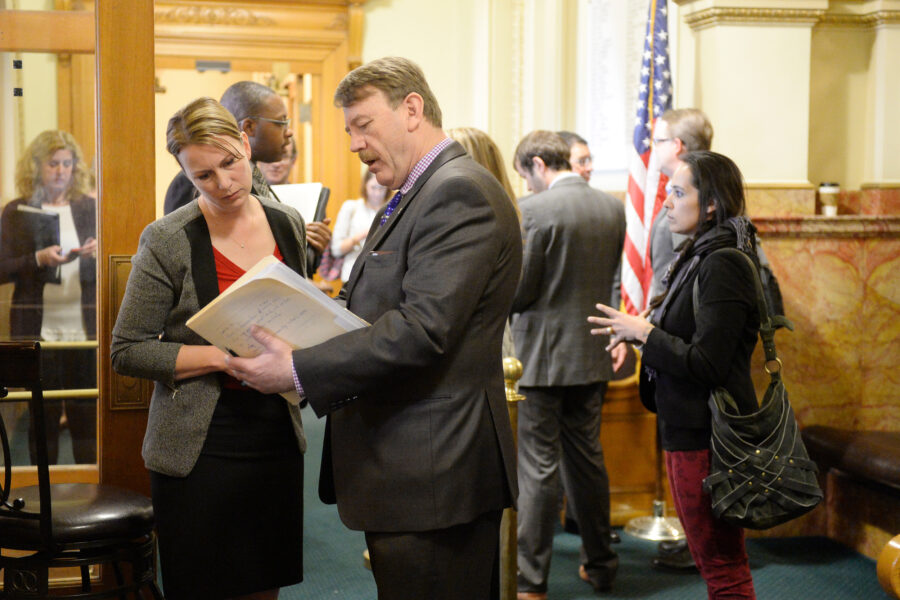 Lobbyist Jim Cole (center) talks with then Colorado Rep. Jessie Danielson at the State Capitol in Denver on Feb. 25, 2016. Credit: Cyrus McCrimmon/The Denver Post via Getty Images