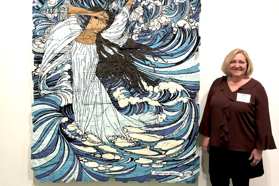 Tish O'Dell, next to artist Andrea Bowers' "We Must Rise Above the Tides," in the Museum of Contemporary Art Cleveland (MoCa). Credit: Katie Surma/Inside Climate News