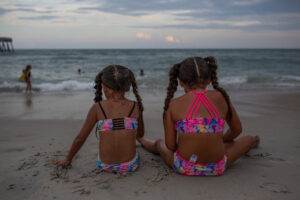 Children sit in the sand at Wrightsville Beach, North Carolina in the evening of July 23, 2023 to avoid the heat of the daytime. Credit: Madeline Gray for The Washington Post via Getty Images