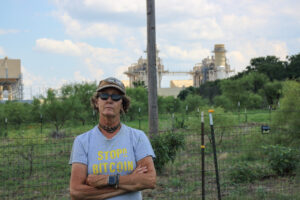 Cheryl Shadden stands outside her home in Granbury, Texas, with a view of Constellation Energy's Wolf Hollow II power plant in the background. Credit: Keaton Peters/Inside Climate News