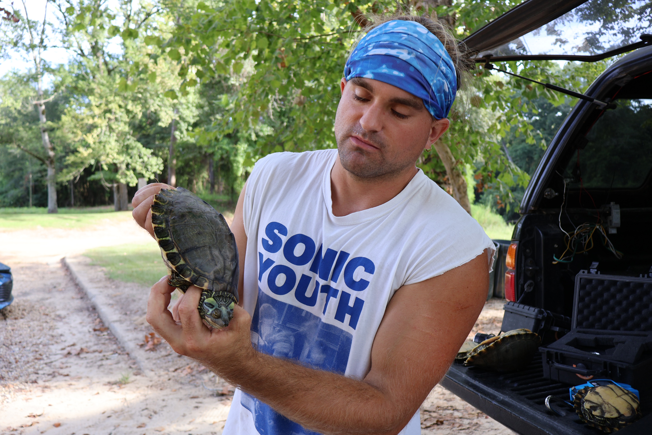 Noah Devros, a graduate student and researcher at the University of Southern Mississippi, holds a female Pearl River map turtle as he collects data and tags the turtles for further research in September 2024. Credit: Elise Plunk/Louisiana Illuminator