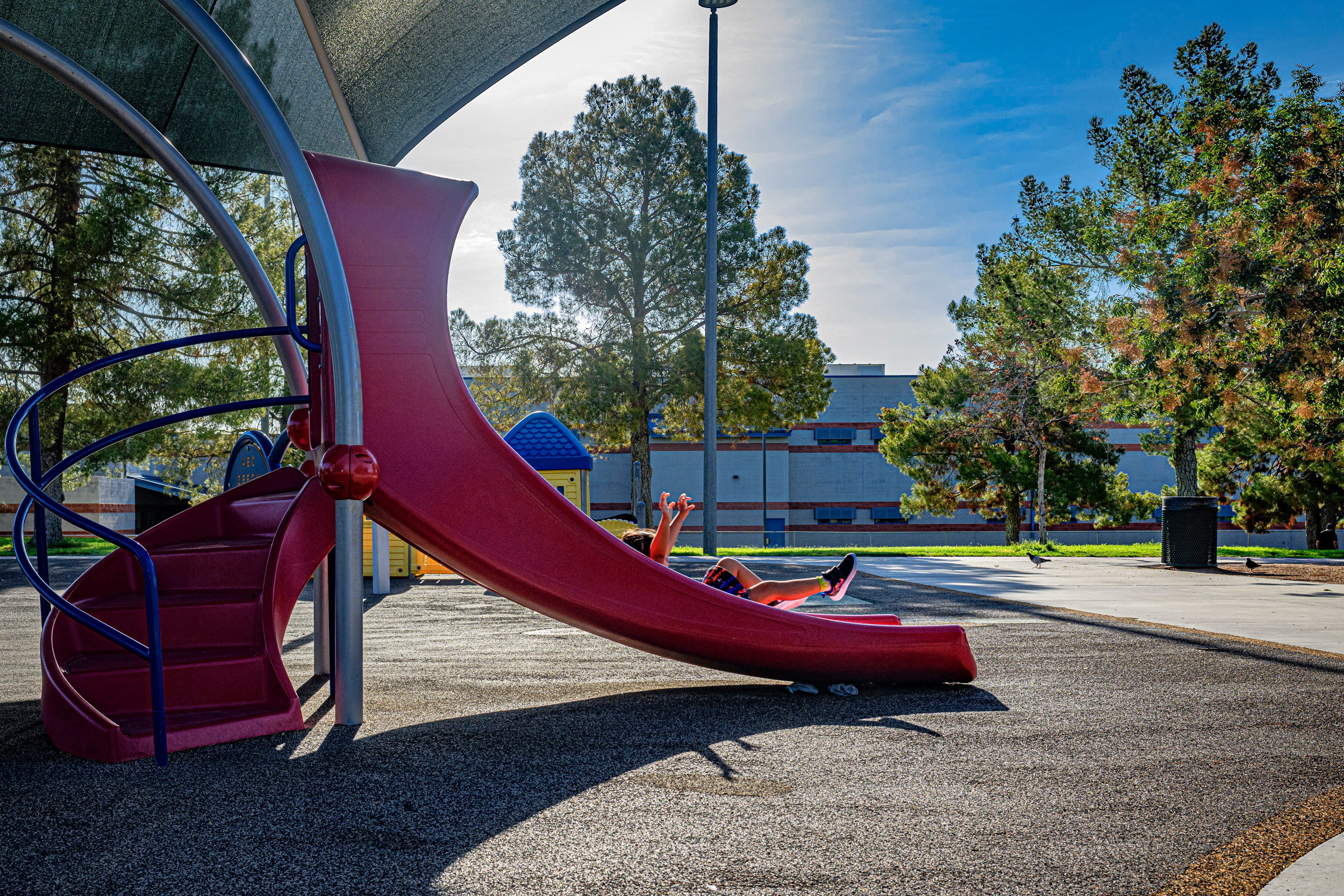 Three-year-old Layla glides down a slide at Kiwanis Park on a hot day in August in Tempe, Arizona. Credit: Kevin Hurley/Inside Climate News
