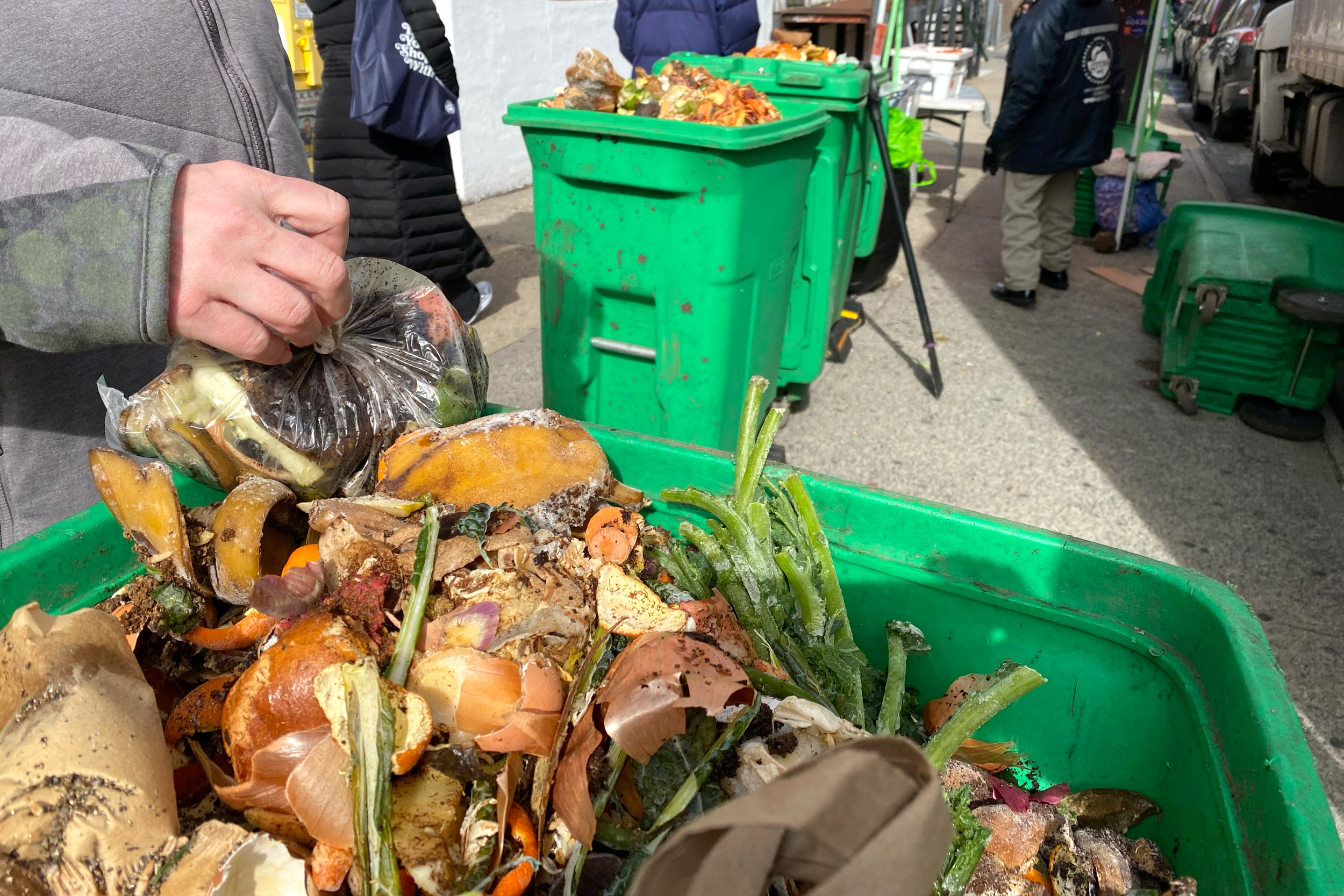 A woman drops off food scraps at a city compost collection site in Queens, New York. Credit: Lindsey Nicholson/Universal Images Group via Getty Images