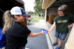 Flor Olvera gives a pamphlet to resident Emma Garcia while canvassing for Rudy Salas, a Democrat running for California's 22nd Congressional District, in Wasco on Aug. 24. Credit: Genaro Molina/Los Angeles Times via Getty Images