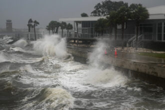 Waves crash along a pier in St. Petersburg, Fla. as Hurricane Milton made landfall on Wednesday night. Credit: Bryan R. Smith/AFP via Getty Images
