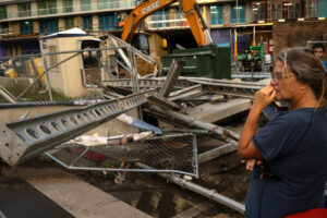 Dawn Fader of Treasure Island, Fla. looks at damage from a fallen crane in downtown St. Petersburg on Thursday after Hurricane Milton swept through the Tampa Bay area. Credit: Thomas Simonetti for The Washington Post via Getty Images
