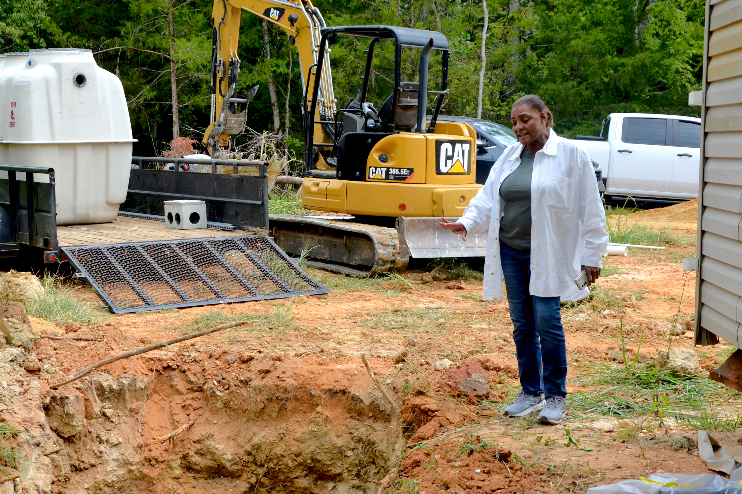 Sherry Bradley, who runs the Black Belt Unincorporated Wastewater Project, explains how a new septic system will work for a mobile home in Lowndes County. Credit: Dennis Pillion/Inside Climate News