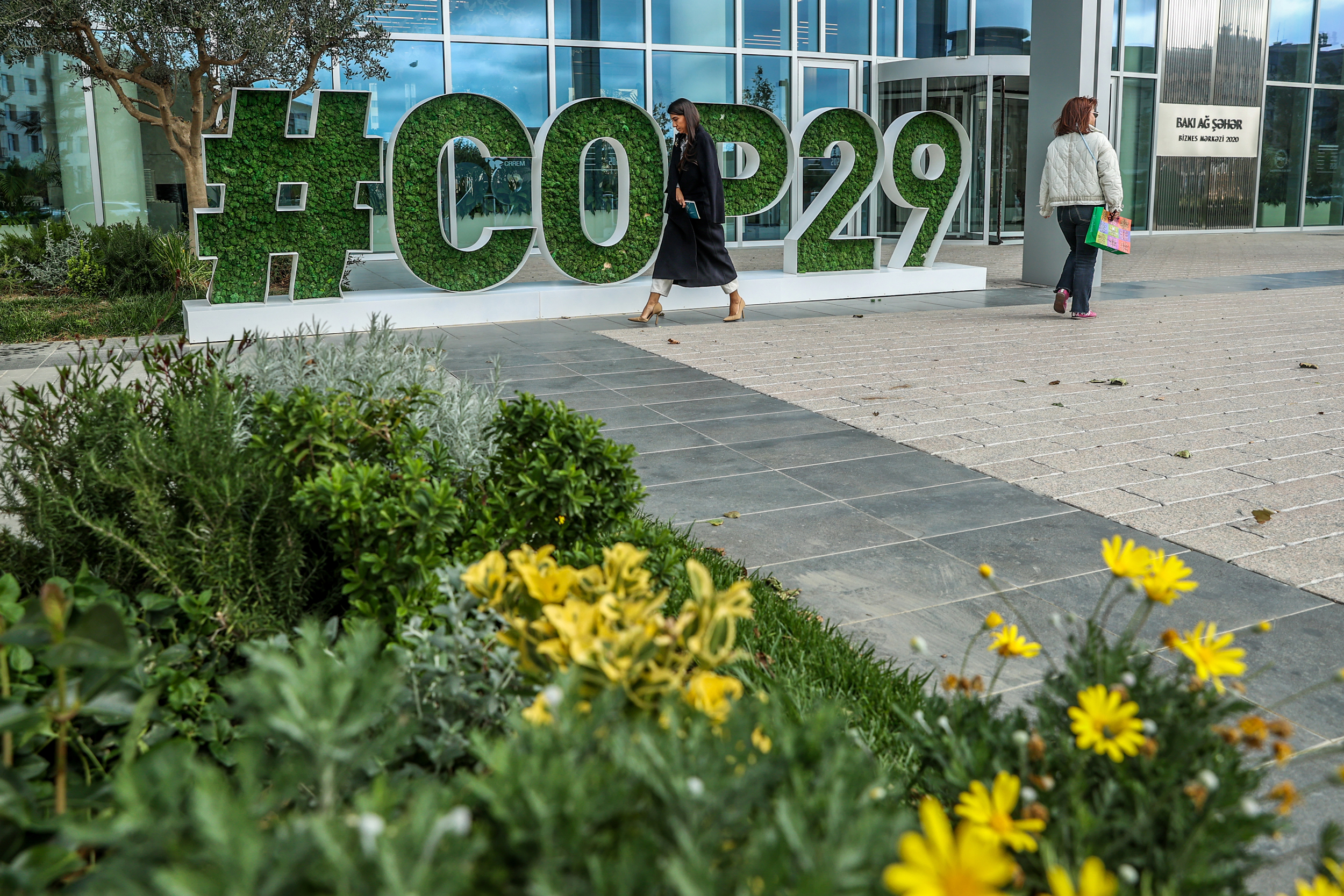 People walk past the COP29 headquarters on Tuesday in Baku, Azerbaijan. The 2024 U.N. climate talks will be held from November 11-22 in Baku. Credit: Aziz Karimov/Getty Images