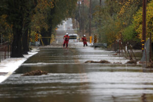 Firefighters block off a flooded road as a powerful atmospheric river brings heavy rains and wind to the San Francisco Bay Area on Nov. 22 in Windsor, Calif. Credit: Justin Sullivan/Getty Images