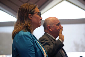 Laura Hogshead (left), the director of ReBuild NC, and Pryor Gibson, advisor to Gov. Roy Cooper, are sworn in to testify in front of lawmakers about the state’s hurricane recovery housebuilding program on Monday. Credit: Galen Bacharier/NC Newsline