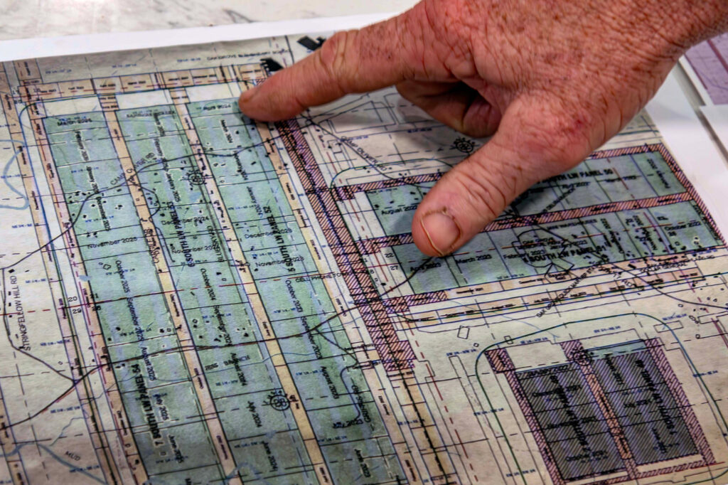 A resident points to the location of his home on a mine map that's been passed between residents searching for more information about the operation expanding beneath them. Credit: Lee Hedgepeth/Inside Climate News