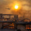 A firefighting helicopter flies near as a home burns from the Mountain Fire on Nov. 6 in Camarillo, Calif. Researchers have found areas exposed to high wildfire hazard will double between 2020 and 2070. Credit: David McNew/Getty Images