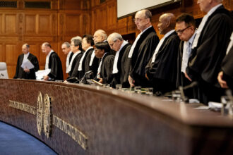 The judges of the International Court of Justice rise during a hearing to set a legal framework on how countries should tackle climate change in The Hague on Dec. 4. Credit: Robin Van Lonkhuijsen/AFP via Getty Images