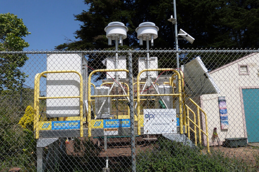 An air monitor at Ohlone Elementary School in Watsonville sits feet away from a playground. The monitor, installed as part of a Civil Rights Act settlement agreement, has long detected unsafe levels of the fumigant 1,3-D. Credit: Liza Gross/Inside Climate News