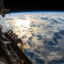 The sun's glint reflects off the Pacific Ocean shadowed by a line of cumulonimbus clouds as the International Space Station orbits about 253 miles above the Earth's surface. Credit: NASA