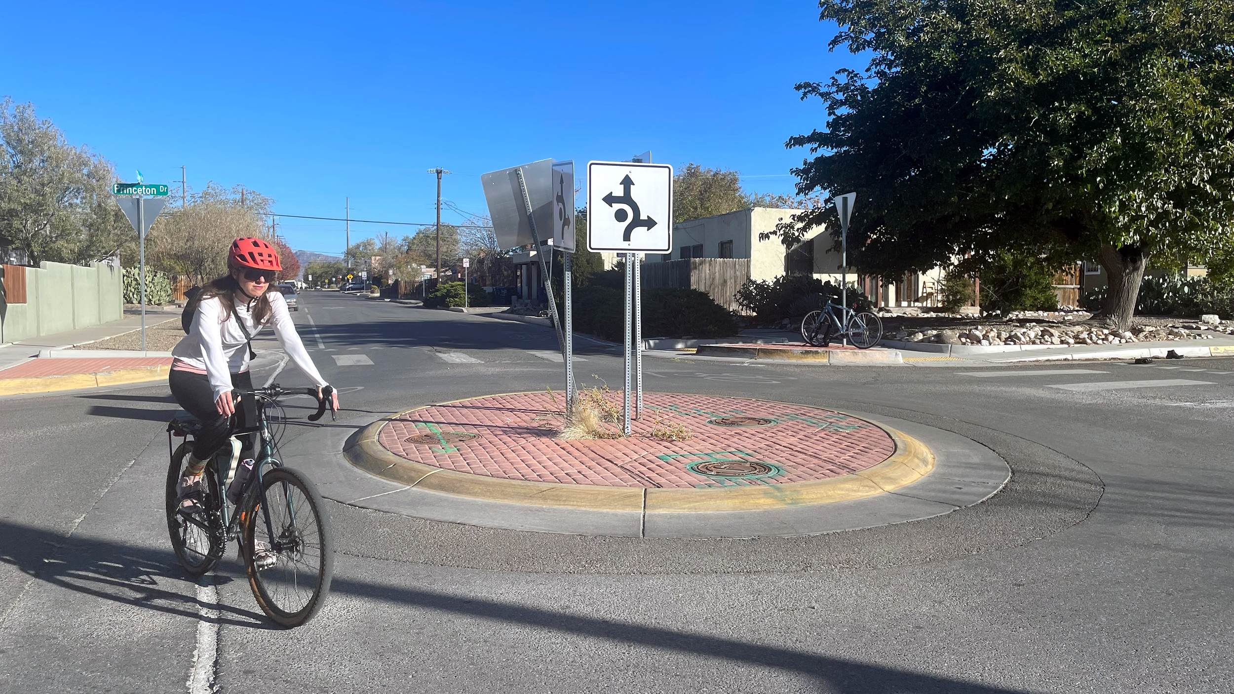 Albuquerque resident Annie Frang rides her bike at a roundabout where she was struck by a vehicle in August 2024. Credit: Tina Deines/Inside Climate News