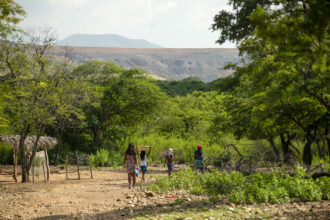 People do chores near the Rancheria River, which runs adjacent to the Cerrejon coal mine in Colombia. The Swiss mining giant Glencore has filed multiple ISDS claims against Colombia related to its investment in the mine. Credit: Lis Mary Machado/Anadolu via Getty Images