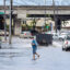 A pedestrian walks across a flooded street in Honolulu on Dec. 7, 2021, the morning after a powerful tropical storm known as a Kona Low hit the Hawaii islands. Credit: Eugene Tanner/AFP via Getty Images