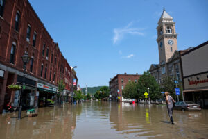 A person walks down a flooded Main Street after two days of heavy rain in Montpelier, Vt. on July 11, 2023. Credit: Kylie Cooper/Getty Images