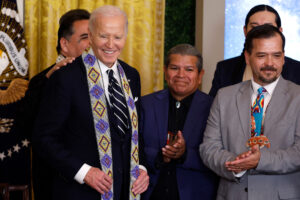 Former President Joe Biden is given a ceremonial sash after singing proclamations creating the Chuckwalla National Monument and the Sáttítla Highlands National Monument at the White House on Jan. 14. Credit: Kevin Dietsch/Getty Images