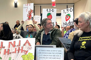 Protesters hold signs in opposition of the cancer-causing 1,3-D at a hearing covering proposed regulation of the fumigant on Jan. 16 in Salinas, Calif. Credit: Liza Gross/Inside Climate News