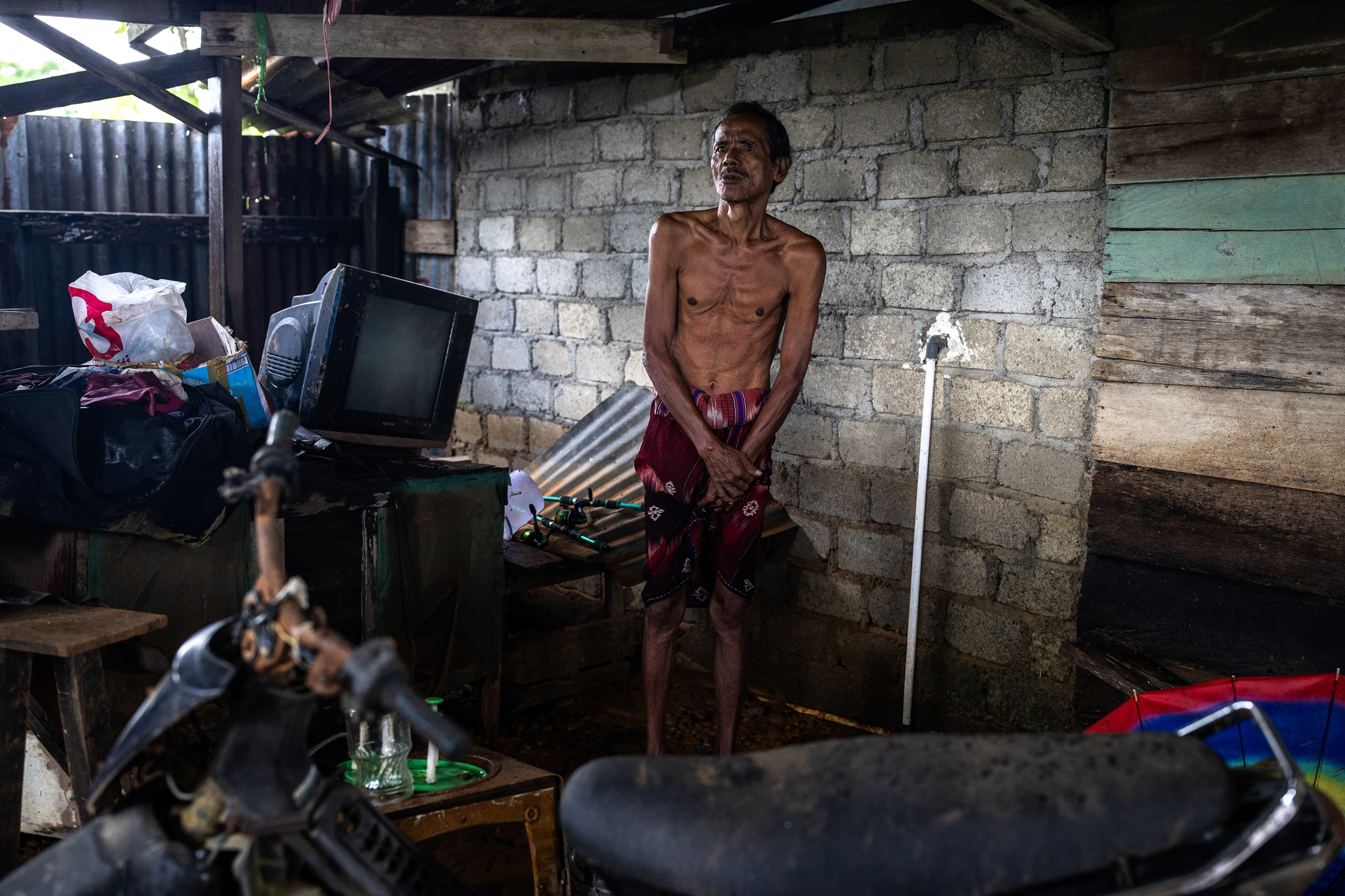 Ahmad Kruwet stands next to the items he salvaged during severe flooding in July at his home in the Woejerana village of Central Halmahera on Aug. 12, 2024.
