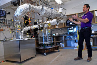Rusty Towell, the founding director of Abilene Christian University's Nuclear Energy Experimental Testing, describes the workings of a molten salt testing device installed in the NEXT lab at Abilene Christian University. Credit: Ronald W. Erdrich/Abilene Reporter-News