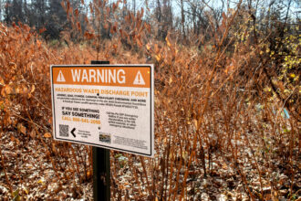 The Mountain Watershed Association posted signs next to the Sewickley creek warning about Hazardous waste from the Max Environmental landfill. Credit: Scott Goldsmith/Inside Climate News