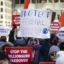 The workers are holding signs with messages like, "Protect federal workers!" and "Stop the Billionaire Takeover"