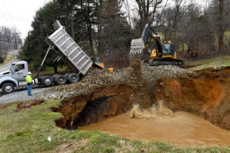 A Pennsylvania Department of the Environment crew fills in a sinkhole above an abandoned mine in Washington Township. Federal funding for remediating old mines has been frozen by the Trump administration, the state said in a lawsuit. Credit: Ben Hasty/MediaNews Group/Reading Eagle via Getty Images