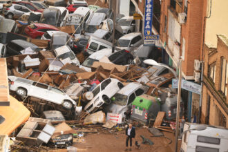 Cars are piled in the street with other debris after flash floods hit Valencia, Spain on Oct. 30, 2024. Credit: David Ramos/Getty Images