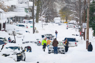 Residents dig out stranded and buried cars after record snowfall on Dec. 2, 2024 in Erie, Pa. Credit: Jeff Swensen/Getty Images