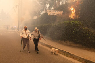 Residents evacuate their home as a brush fire burns on Jan. 7 in the Pacific Palisades neighborhood of Los Angeles. Credit: Qian Weizhong/VCG via Getty Images
