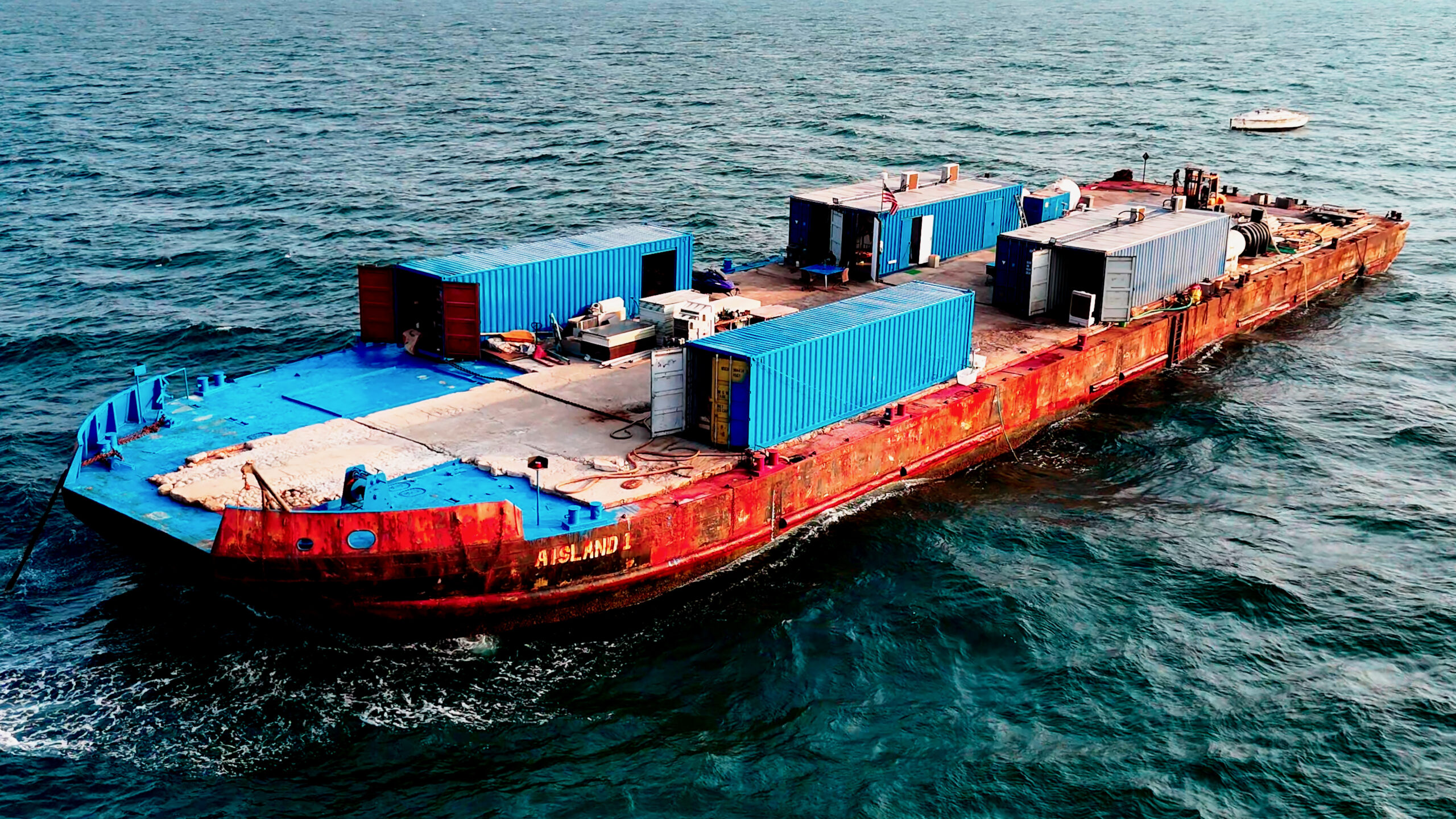 In 2022, Samuele Landi bought an initial 800-ton deck barge that he named Aisland and anchored roughly 30 miles off the coast of Dubai, where he lived with three sailors, a cook and five cats. Credit: The Legend of Landi by Oswald Horowitz/The Outlaw Ocean Project