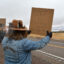 Owen Crowlie and Trevor Lauber display their protest signs to visitors of Chiricahua National Monument on March 15 in Cochise County, Ariz. Credit: Wyatt Myskow/Inside Climate News