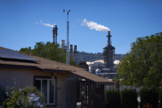 An oil refinery operates next to a neighborhood of homes in Wilmington, Calif. Credit: Allison Dinner/Getty Images