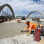 Workers smooth cement during the construction of the Sixth Street Bridge in Los Angeles on April 26, 2022. Credit: Gary Leonard/Getty Images