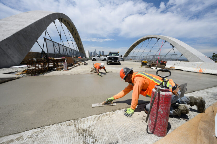Workers smooth cement during the construction of the Sixth Street Bridge in Los Angeles on April 26, 2022. Credit: Gary Leonard/Getty Images