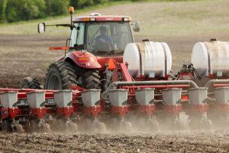 A farmer plants corn using a Case IH tractor and 16-row planter assisted by an on board computer that monitors and controls seed and fertilizer application. Credit: Andrew Sacks/Design Pics Editorial/Universal Images Group via Getty Images
