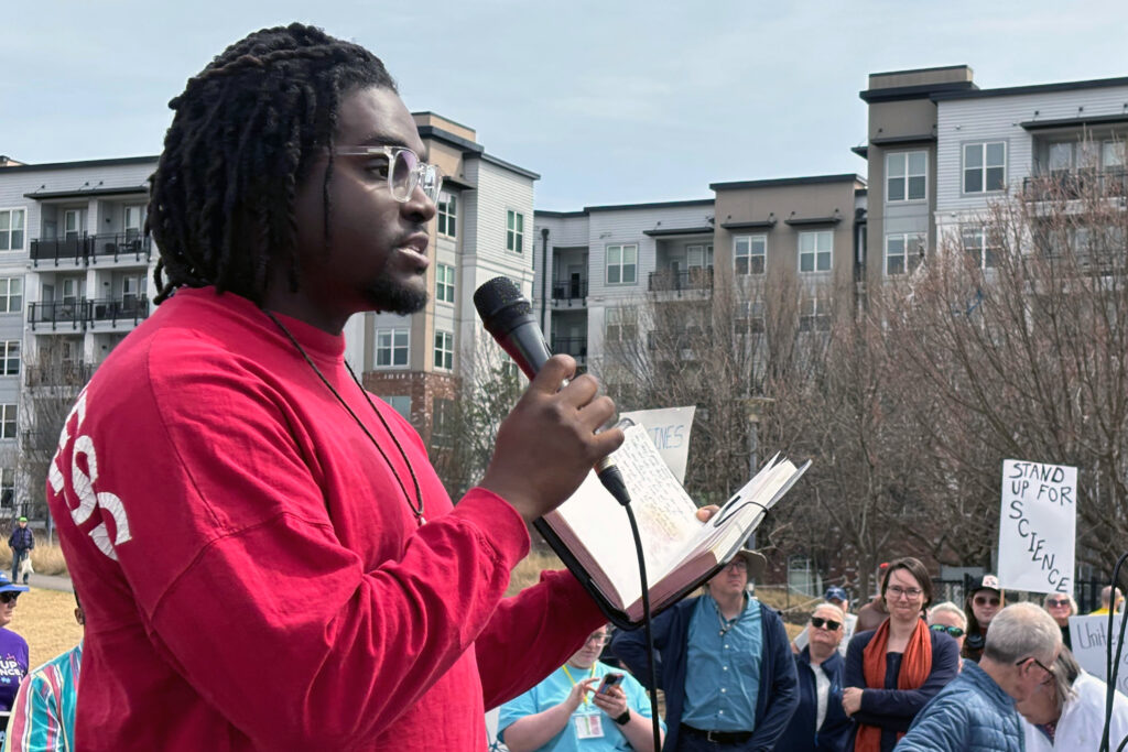 PhD student Joshua Lewis addresses the crowd in Birmingham’s Railroad Park. Lewis had a postdoctoral fellowship offer rescinded due to funding concerns after Trump budget cuts. Credit: Dennis Pillion/Inside Climate News